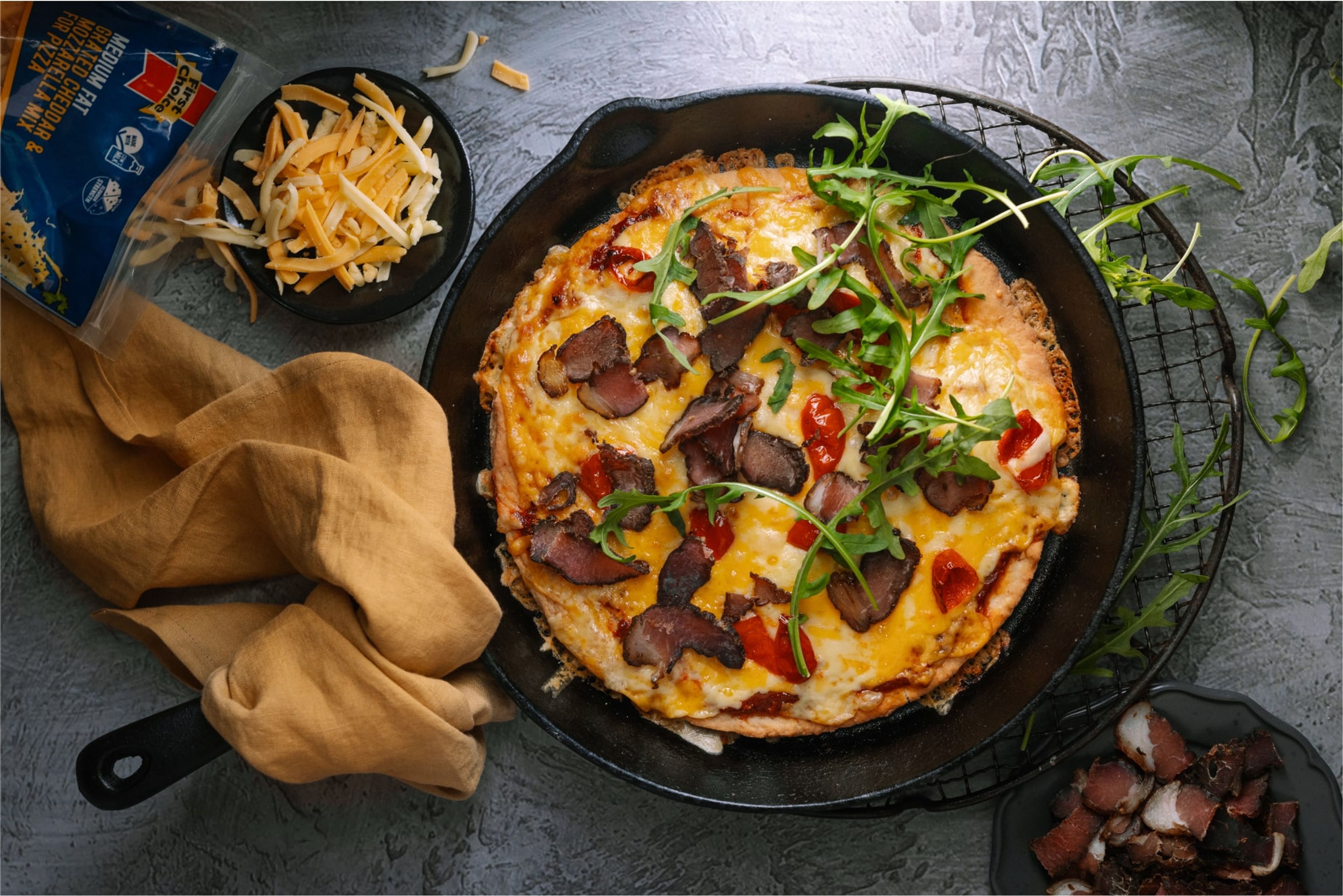 Pan pizza with biltong, rocket and peppedwes