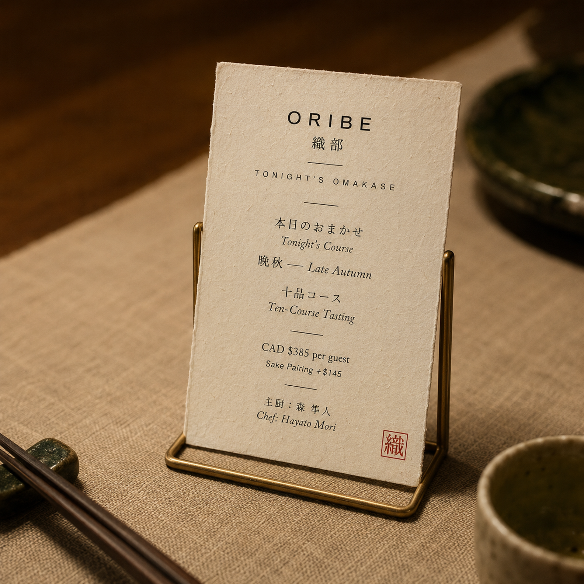 桌面立式菜单卡 —— 黄铜底座陈列今晚 omakase 与"織"字红印