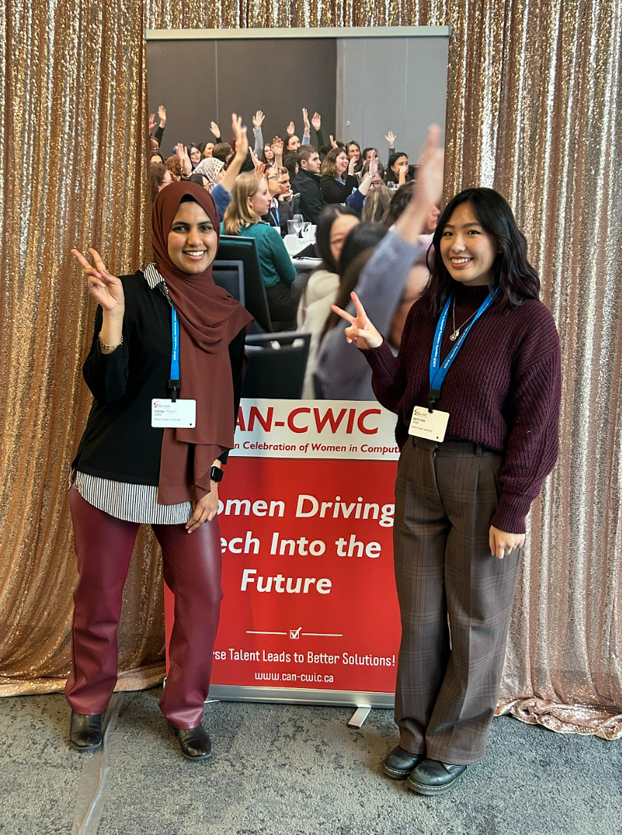Kaitlynn and Mehreen infront of CAN-CWiC banner