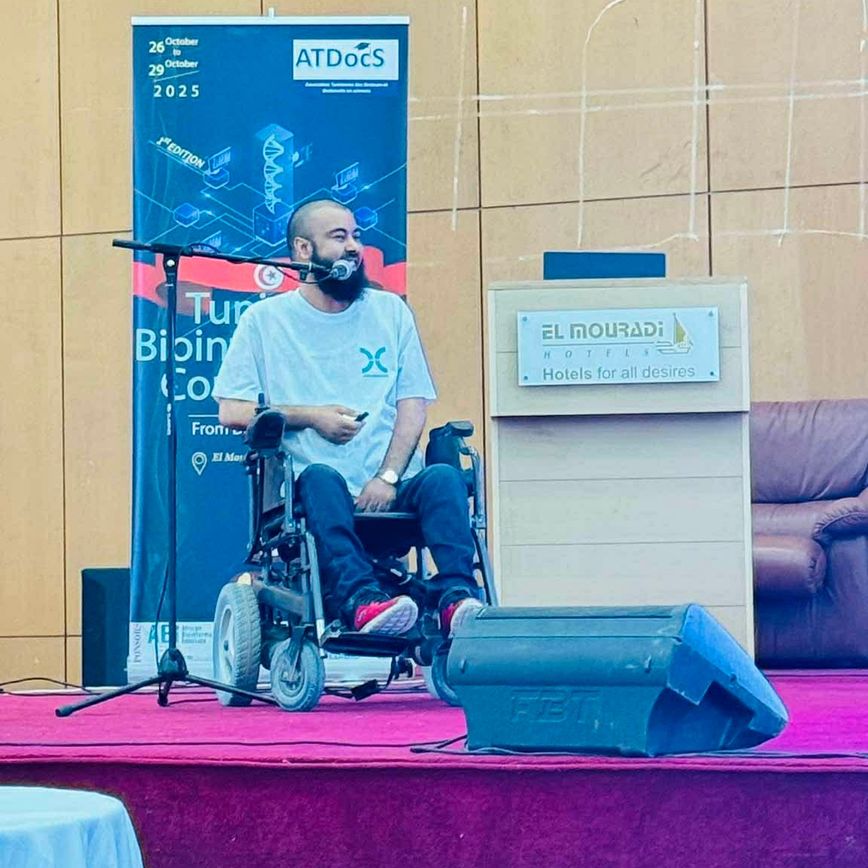 Firas on a stage giving a talk