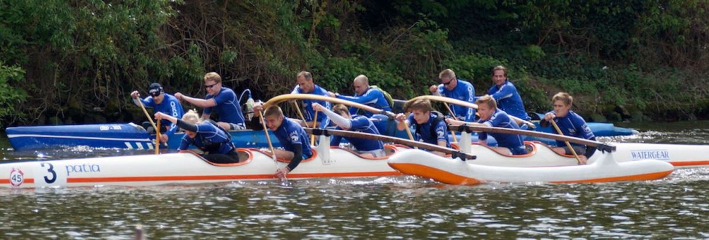 Outrigger-Auslegerkanu mit Paddlern auf dem Main
