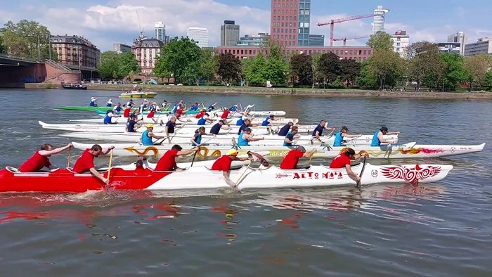 Start mehrerer 6er Mannschafts Auslegerkanus vor der Skyline von Frankfurt am Main