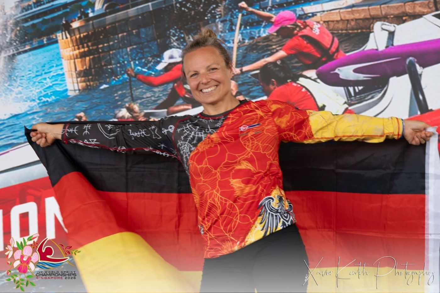 Christiane Pape (FRVS 1898) hält lachend die ausgebreitete Deutschlandflagge in die Kamera.