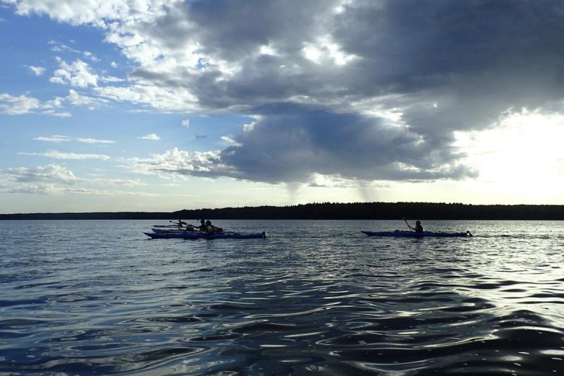 Gewitterwolken mit Regenschauer über der Müritz, in der Ferne Kajaks.