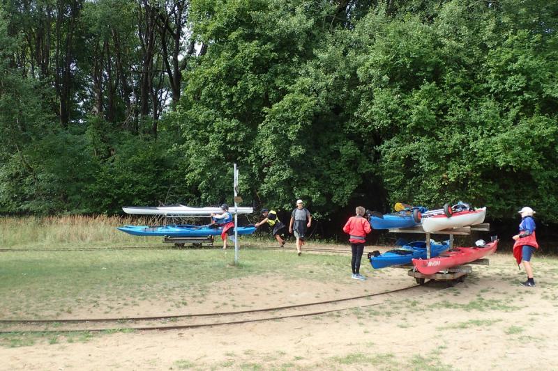 Kajaks auf Bootswagen an der Umtragestelle mit Schienen.
