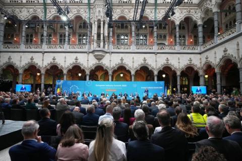 A speaker addresses a large audience at the European Industry Summit 2024 in an ornate hall.