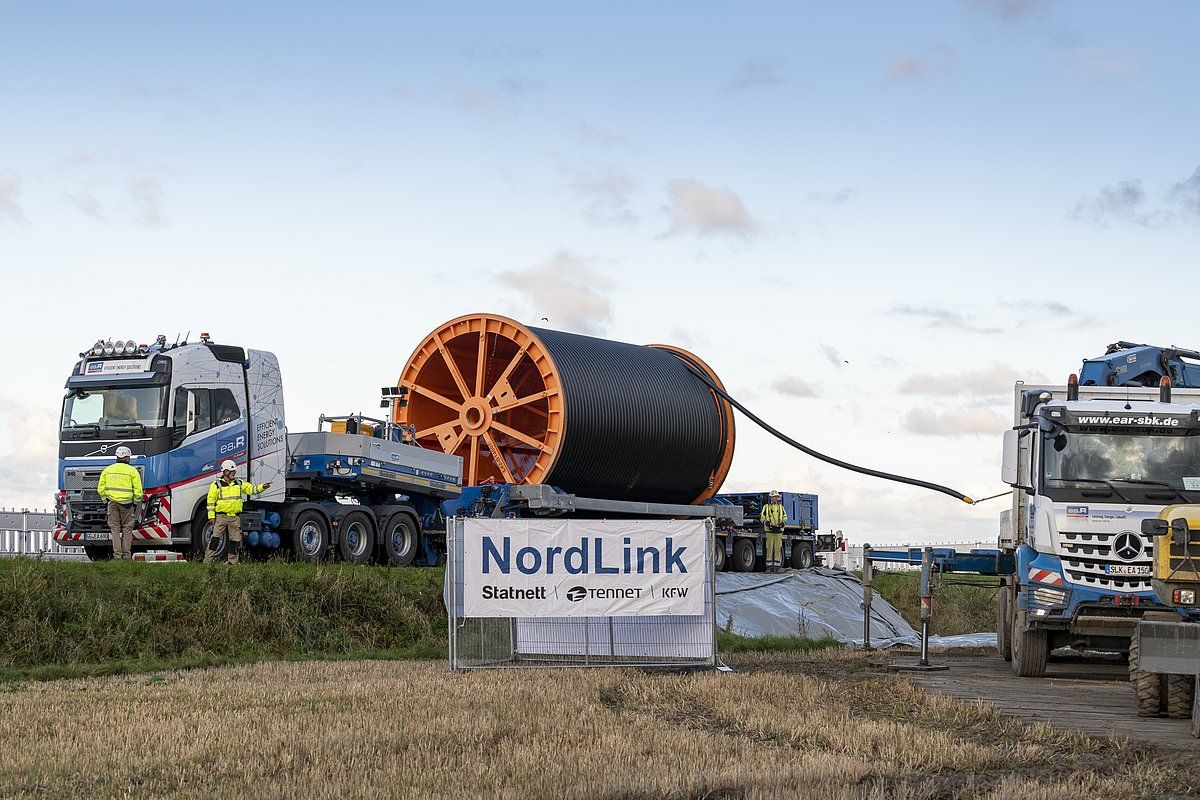 En enorm kabeltrommel på en spesialtransportbil, med arbeidere og et NordLink-skilt.