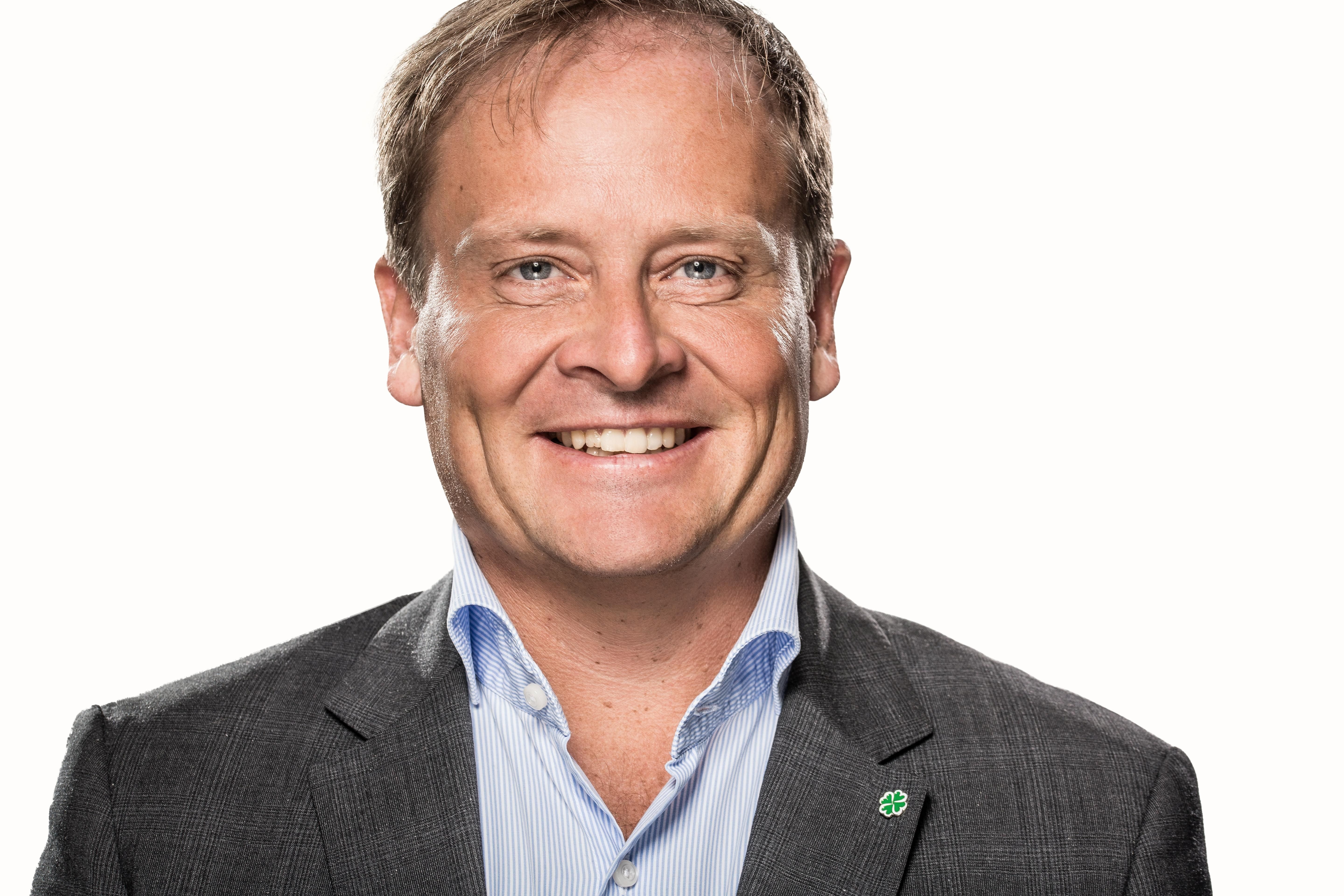 Bildet viser tidligere Senterpartipolitiker, Erlend Grimstad, i dressjakke med en firkløver-pin.