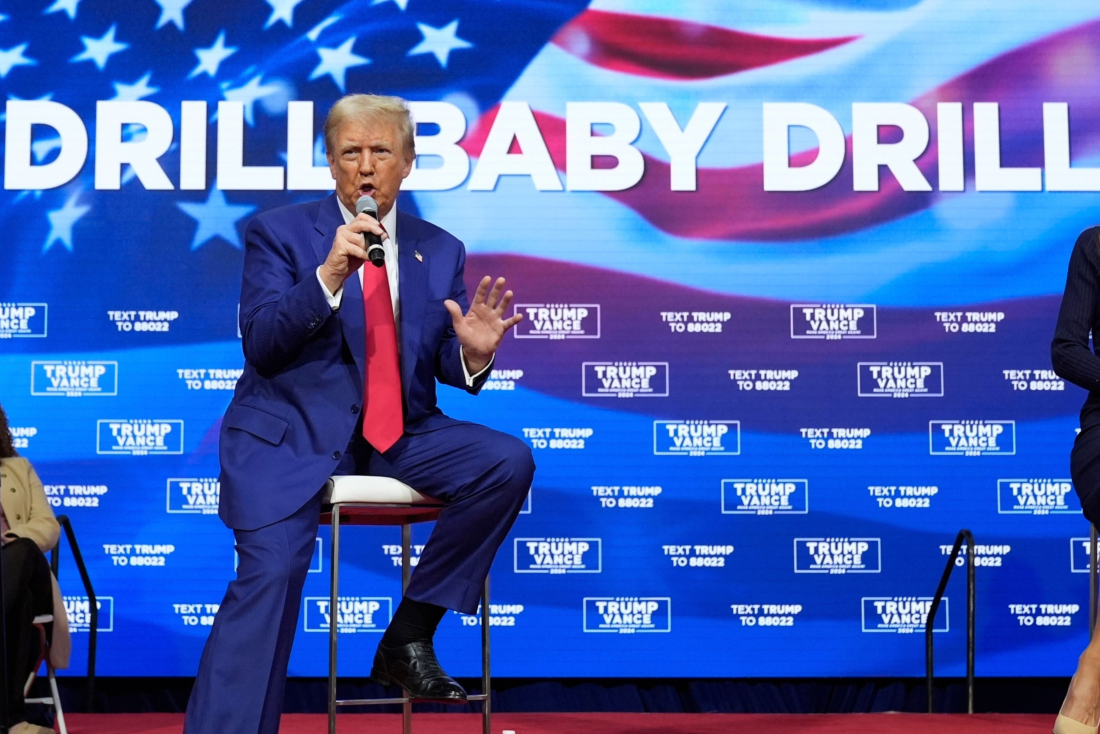 Presidentkandidat Donald foran et amerikansk flagg og teksten "Drill baby drill".