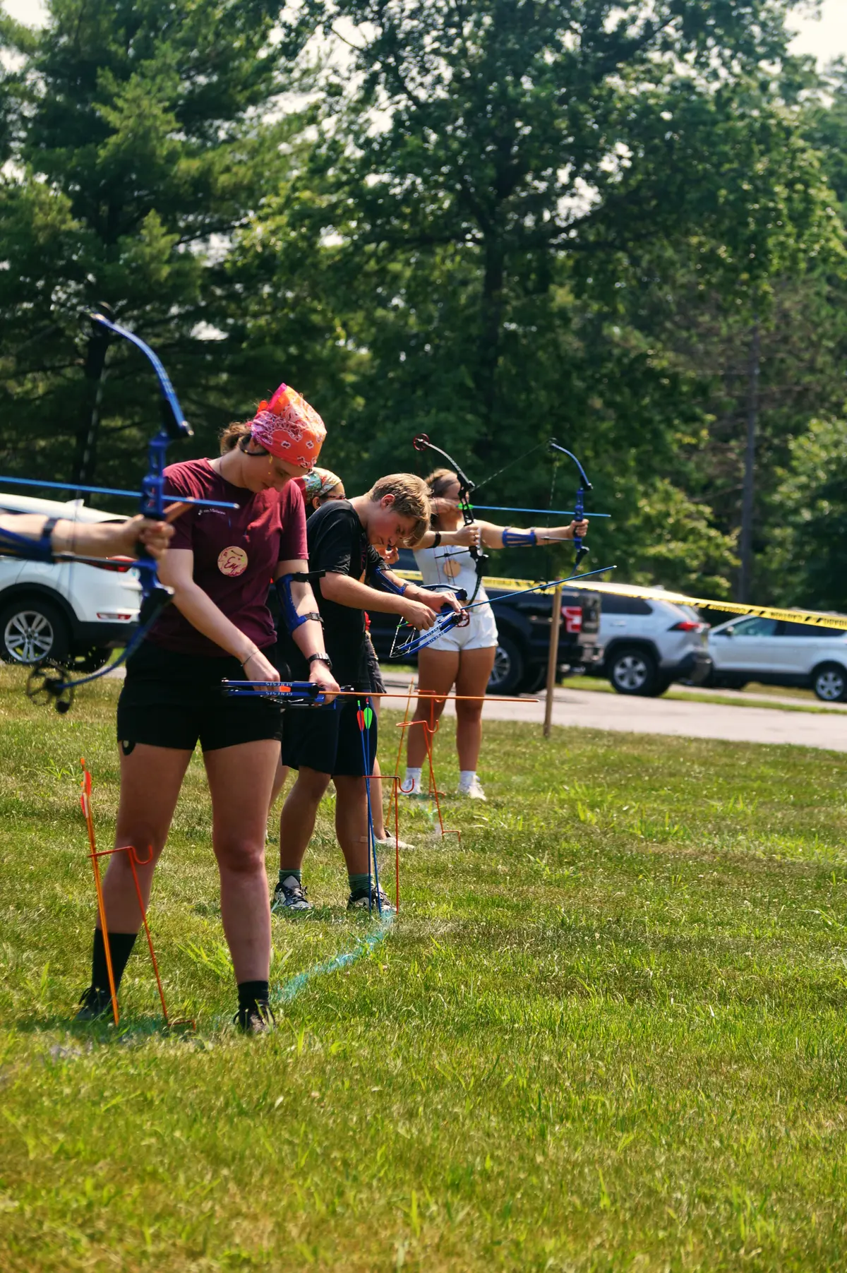 Young campers practicing archery on a sunny field