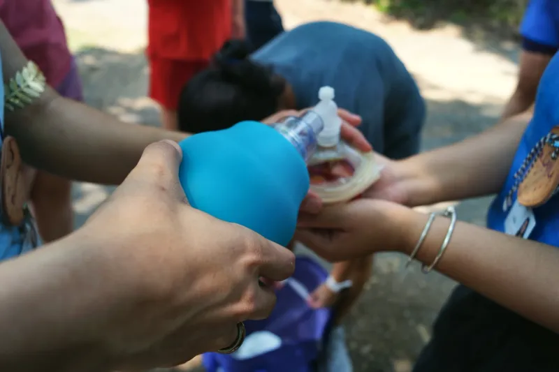 Hands practice with a bag-valve-mask resuscitator during a training session.