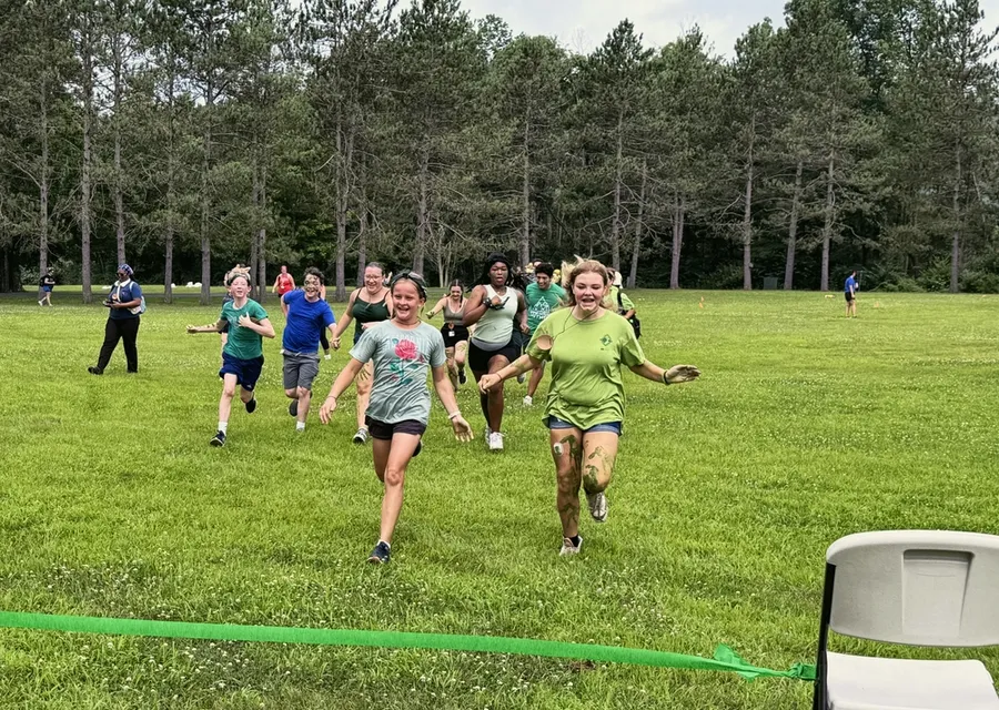 Campers running to the finish line of an obstacle course