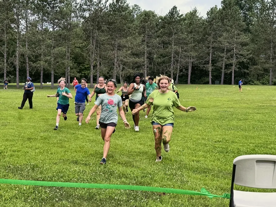 Campers running to the finish line of an obstacle course