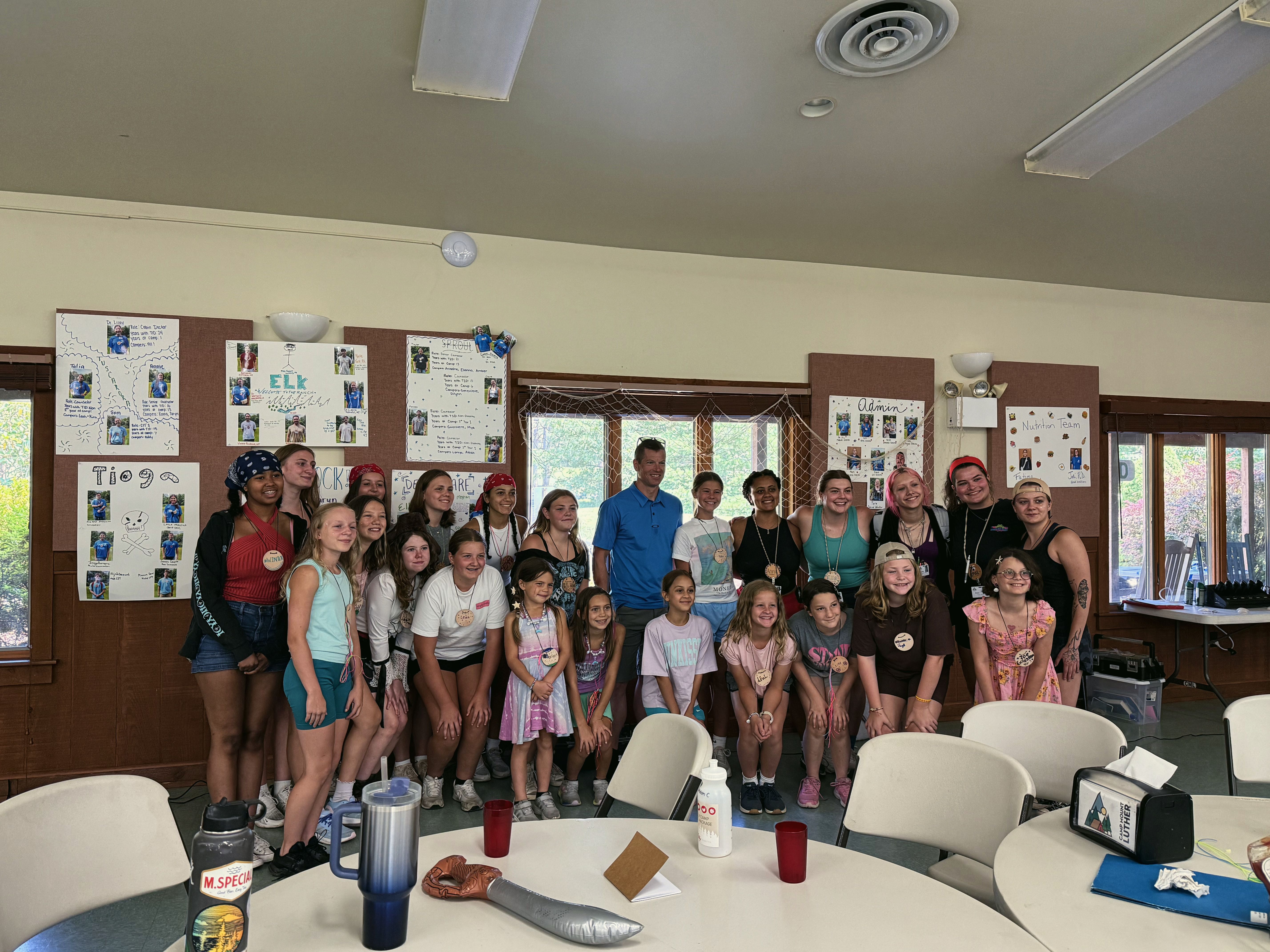 Children and adults stand together for a group photo indoors