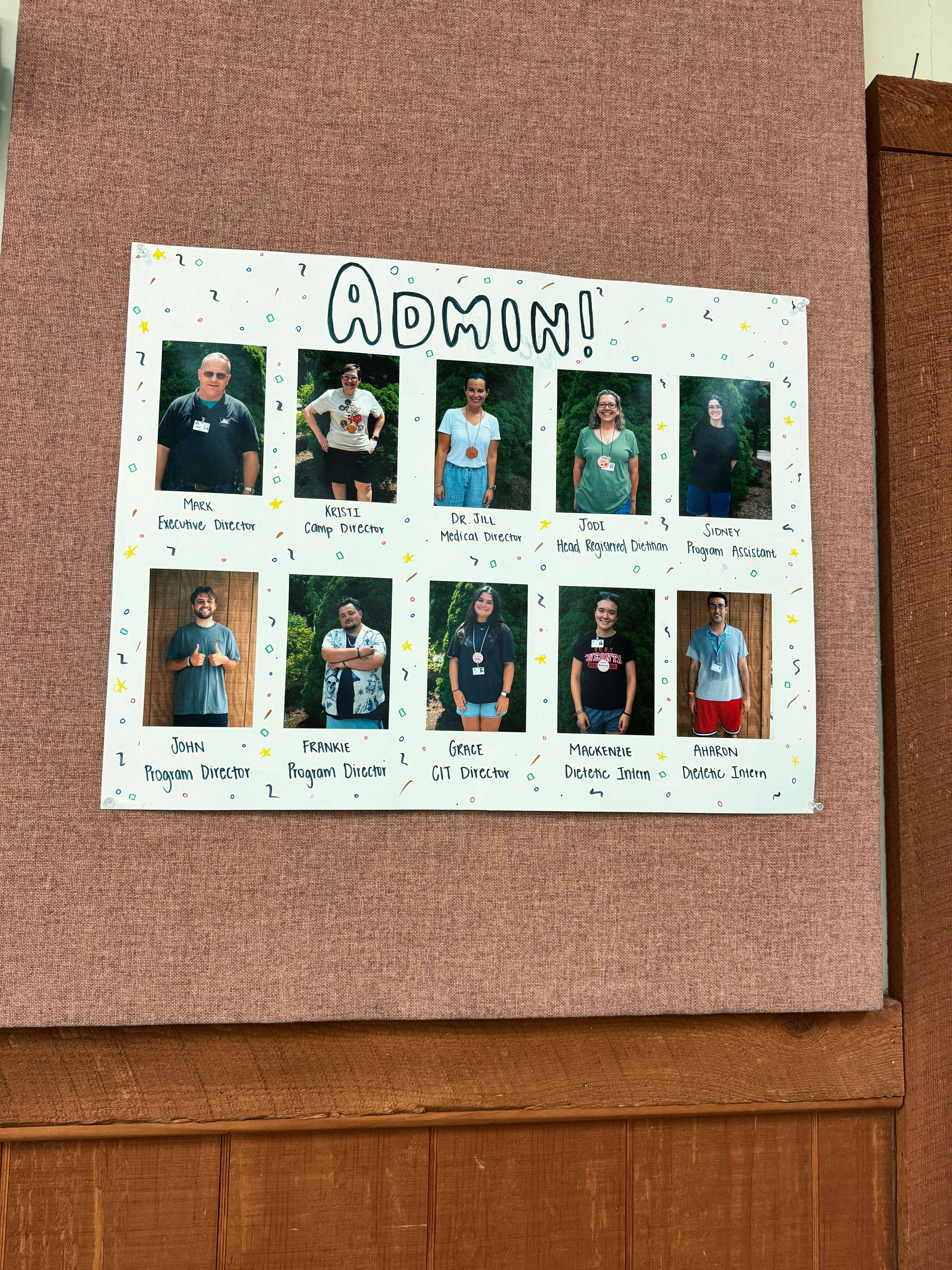 A camp poster titled "Admin!" with photos of ten camp leaders, each with a first name and role, starting with Mark, Executive Director