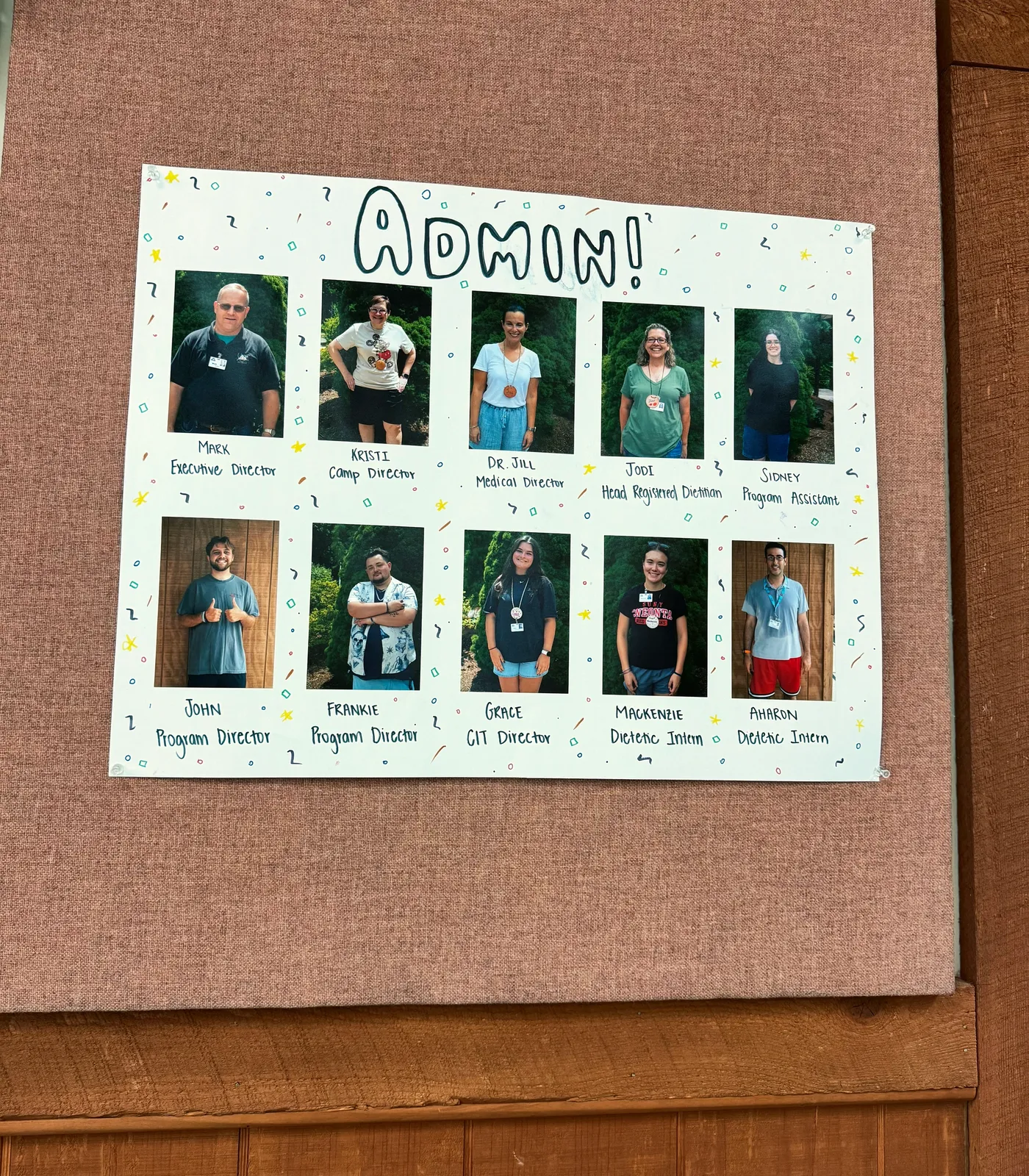 A camp poster titled "Admin!" with photos of ten camp leaders, each with a first name and role, starting with Mark, Executive Director