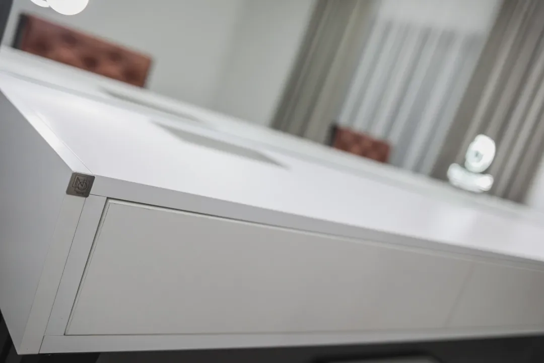 Detalj bijelog šminkerskog stola sa obradom ruba i fiokom