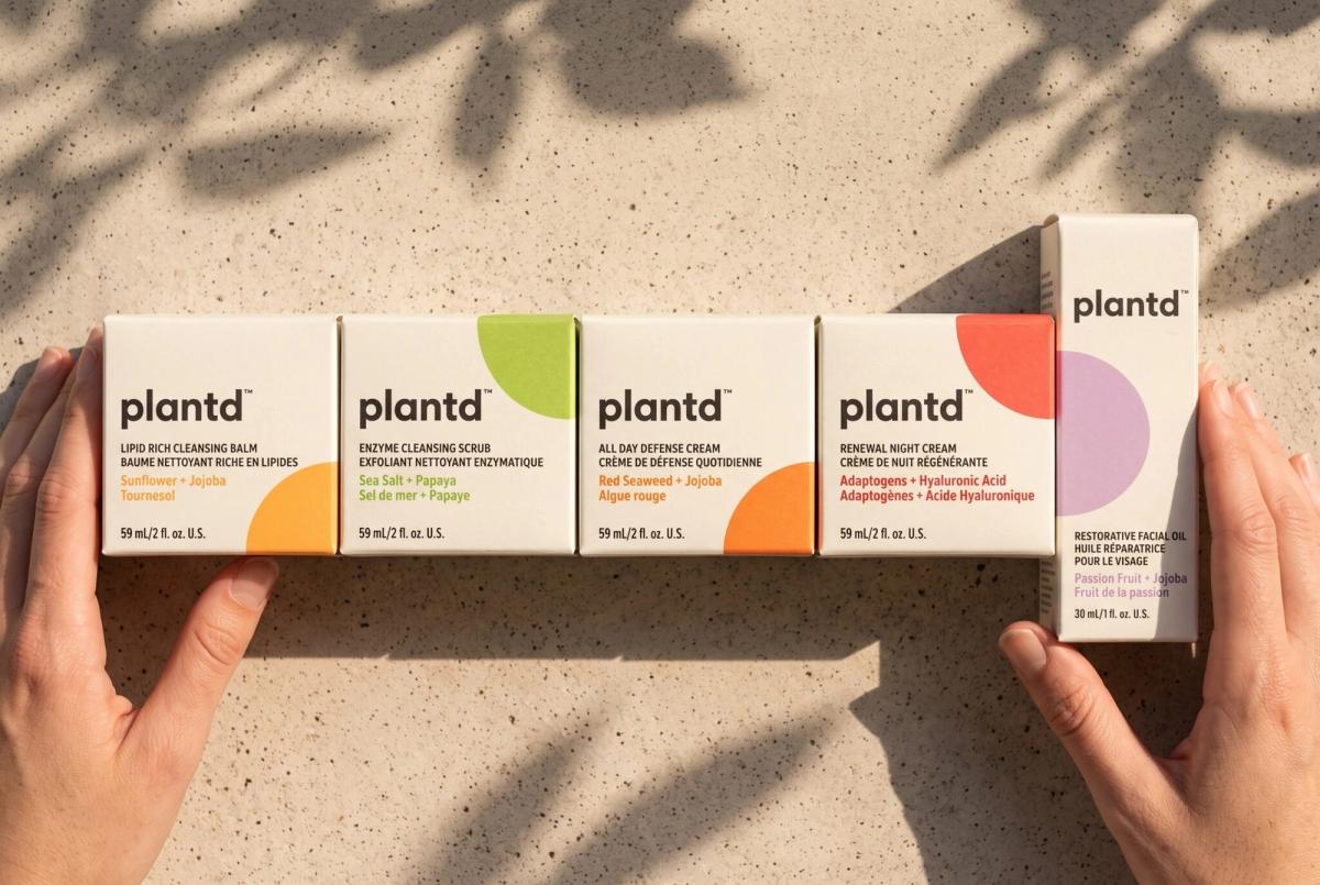 Hands holding a row of five Plantd skincare cartons in uncoated FSC paperboard