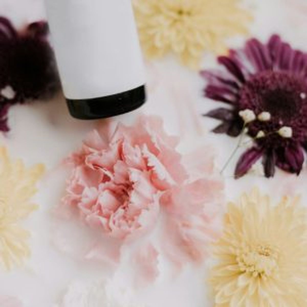 Flat lay of skincare products with dried flowers