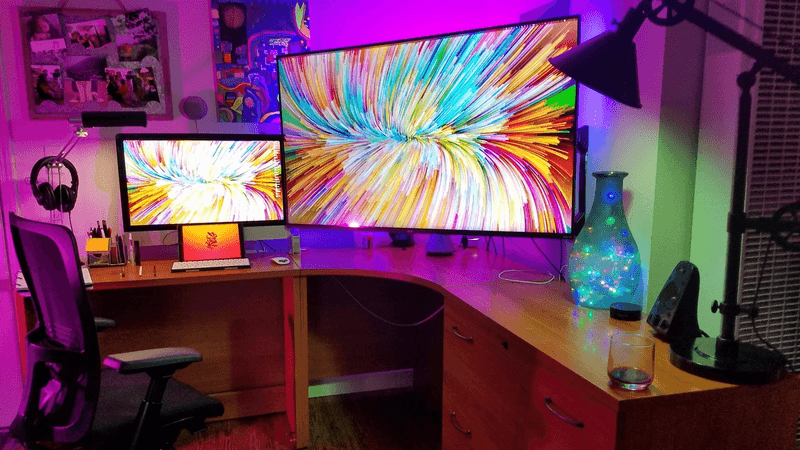 Triple monitor setup with colorful screensaver