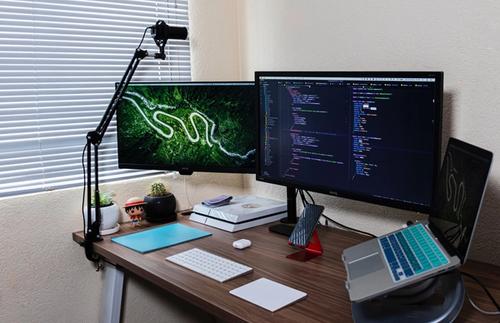 Dual monitor desk setup with laptops