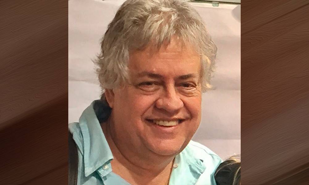 Edson Marchiori, homem branco, idoso, de cabelos brancos.