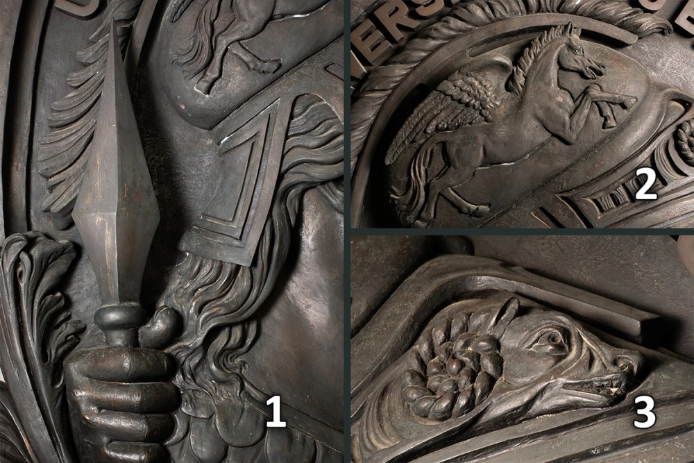Detalhe em close dos signos representados em relevo no medalhão da Minerva, em sentido horário e numeração: 1 a lança, 2 o pégaso e 3 o carneiro 