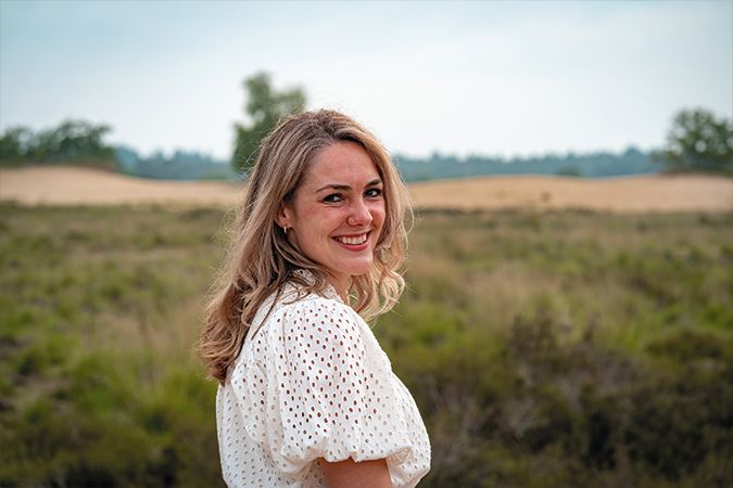Jonge vrouw kijkt over haar schouder op de Loonse en Drunense Duinen