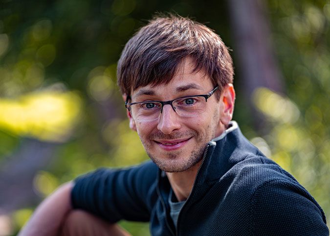 Jongeman zittend op een bankje in een park in Amsterdam
