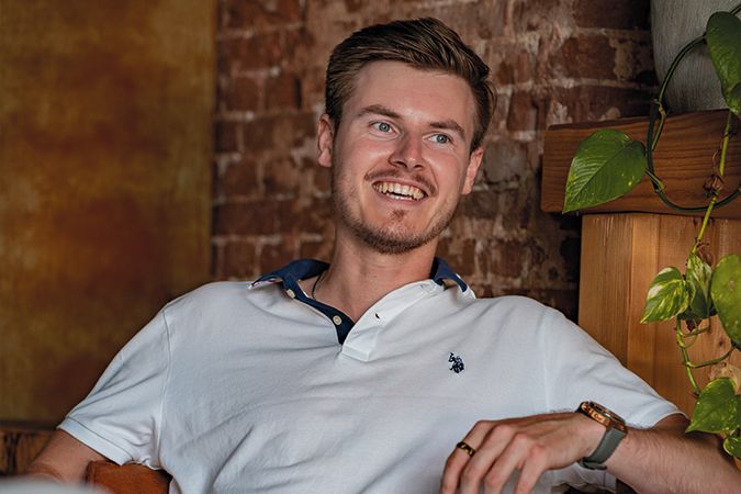 Jongeman zit op een stoel in een café