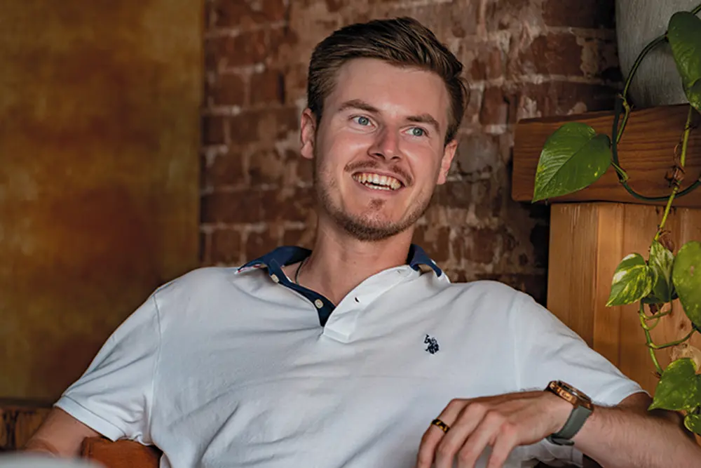 Jongeman zit op een stoel in een café