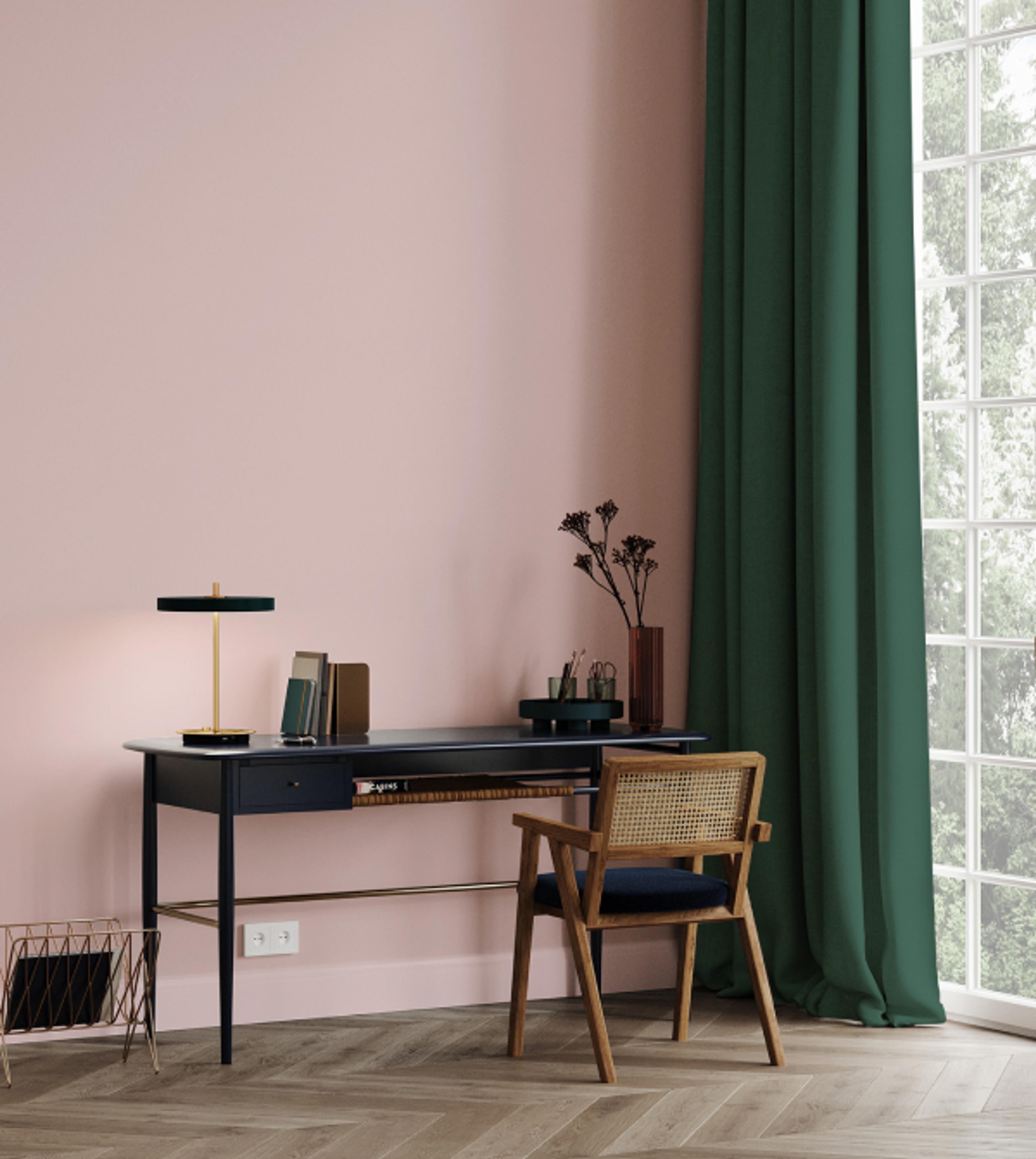 Pult med en rosa vegg og grønn gardin