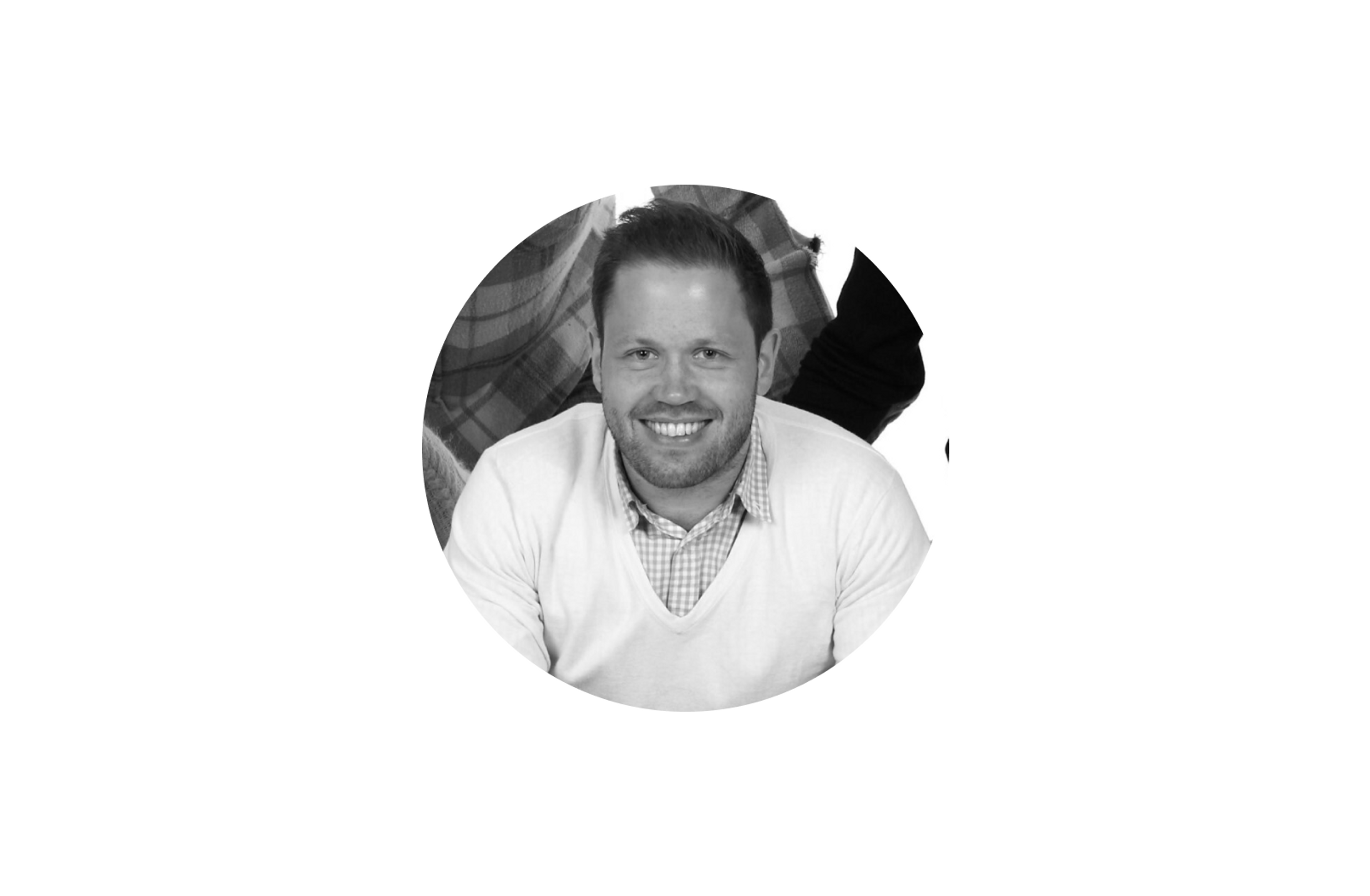 Svart/hvitt-bilde av en mann som smiler.