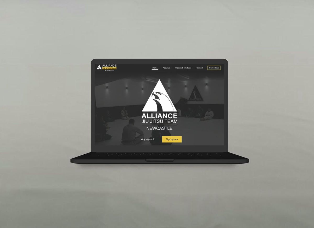 Website mockup of a laptop showing the hero section for the Alliance Jiu Jitsu Newcastle website