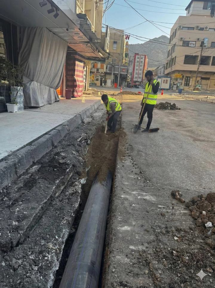 Workers installing pipe in a trench