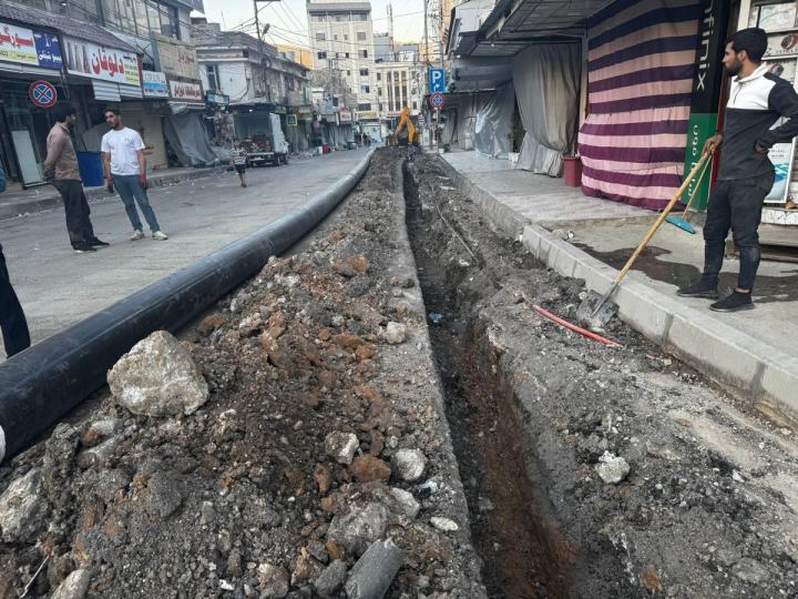 Workers installing pipe in a trench