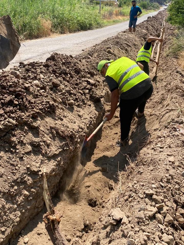 Workers installing pipe in a trench