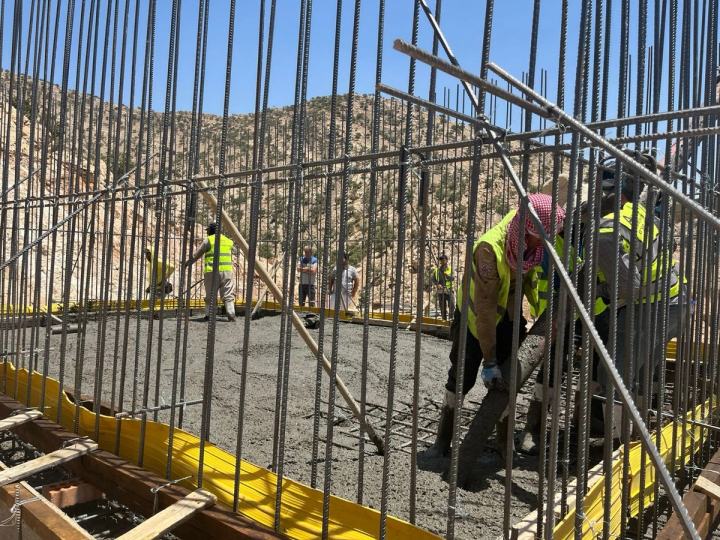 Workers installing pipe in a trench
