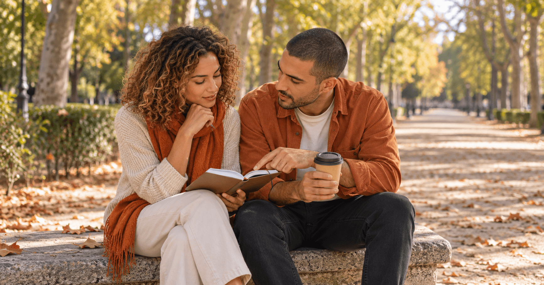 Pareja sentada en un banco del parque de El Retiro, en Madrid, mirando juntos una agenda mientras planifican las fechas de su visa de nómada digital de España