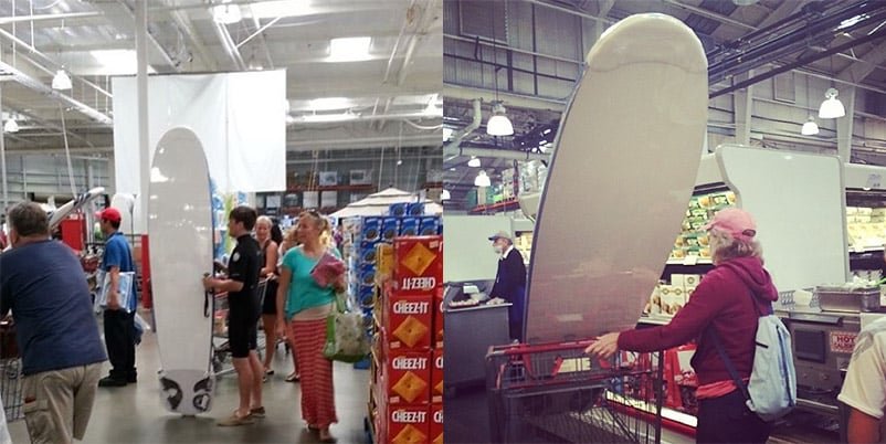 Shoppers in a warehouse store push carts with tall white surfboards standing upright in them.