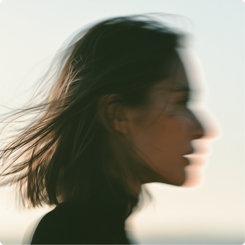 Profile of a person with wind-blown hair looking toward the horizon
