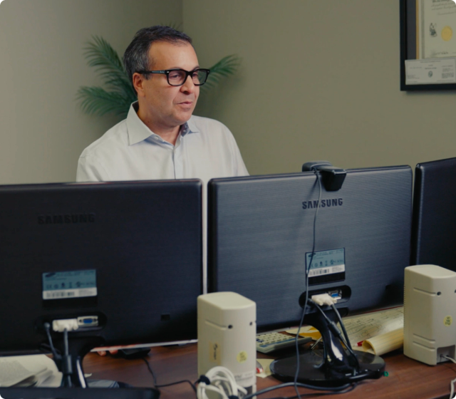 Lawyer sitting in front of multiple screens at a desk