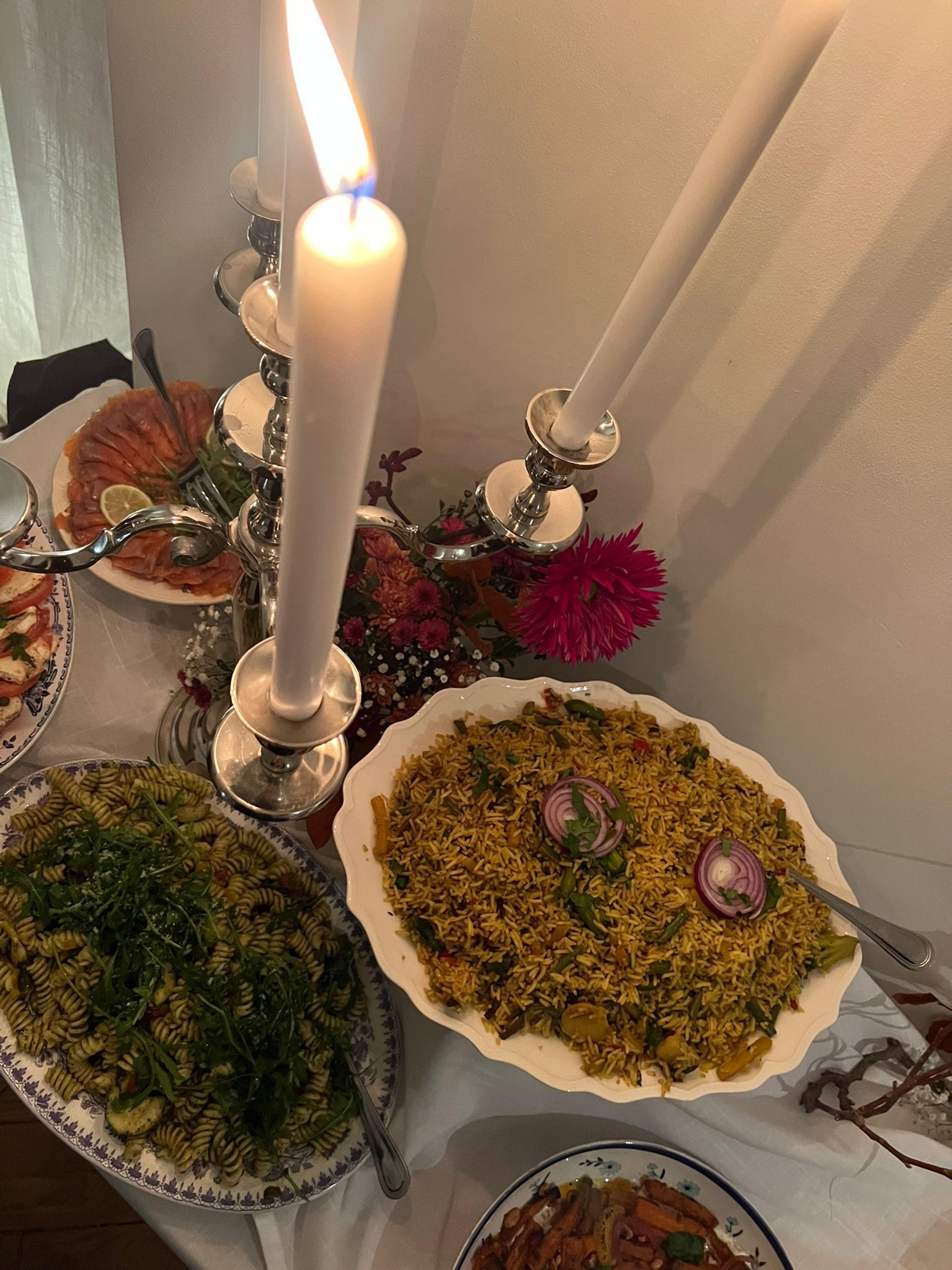 Lange tafel met blauw-witte streep in het gras, bloemen en kussens