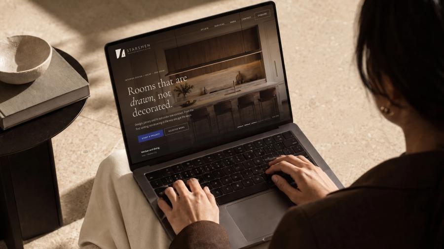 Someone at a laptop with the Starsmen website open, seen over their shoulder.