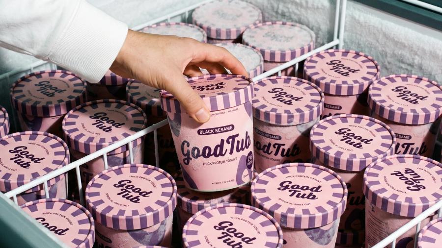 A hand lifting one GoodTub pot from a supermarket chiller packed with them.