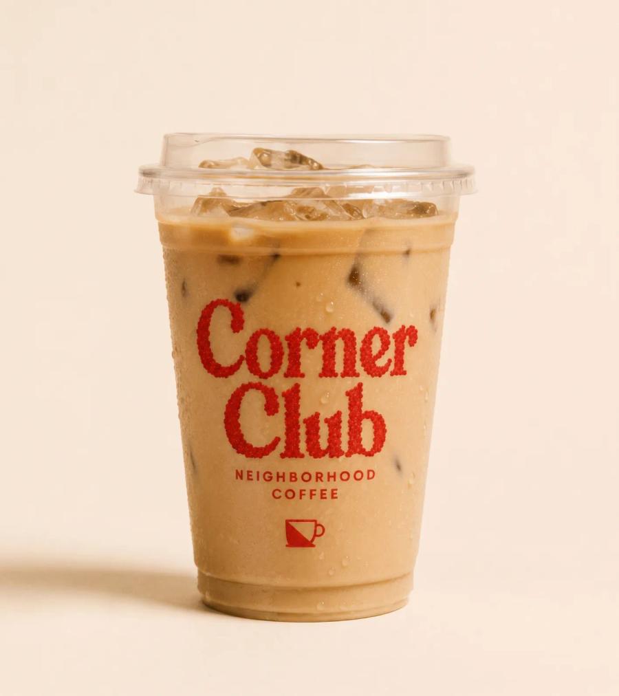 An iced Corner Club coffee in a branded cup against bone.