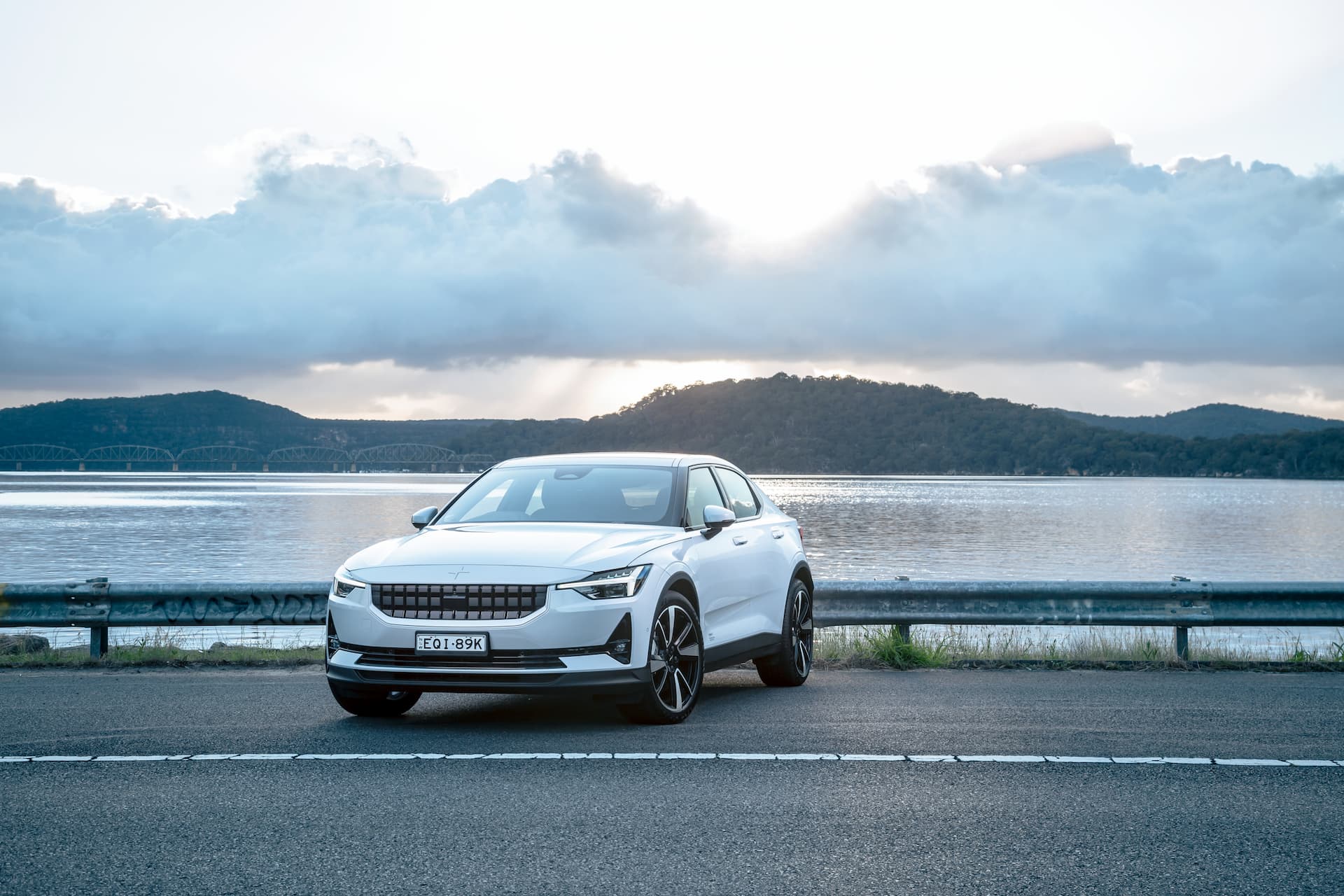 White Polestar 2 electric car in front of lake