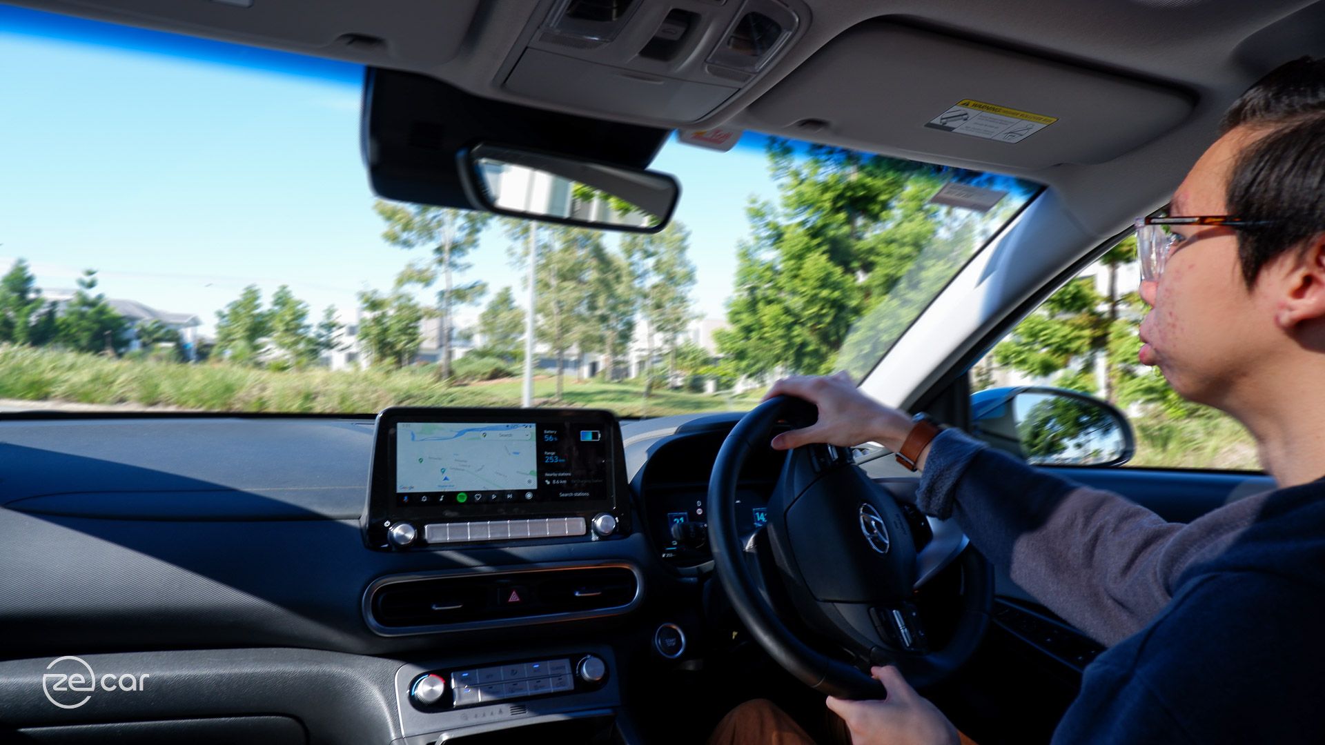 Person driving Hyundai Kona Electric interior dashboard view
