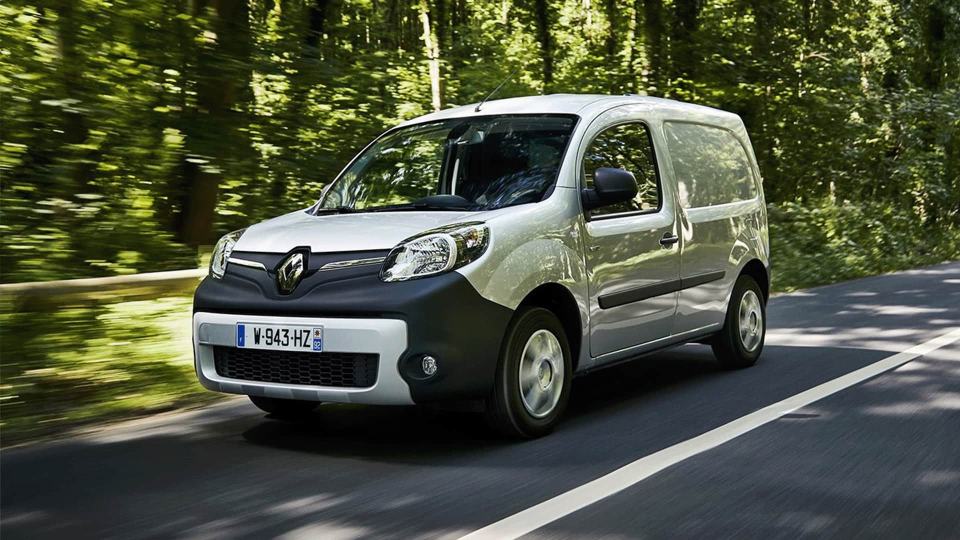 Grey Renault Kangoo ZE driving the cemented road in forest