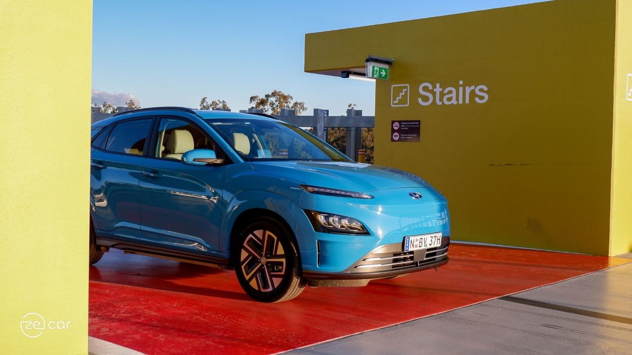 Dive in Jeju Hyundai Kona Electric in front of yellow wall and 'stairs' sign